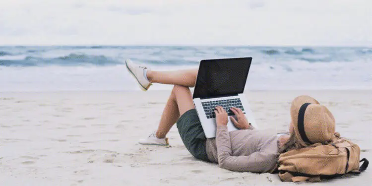 freelance worker sitting on beach