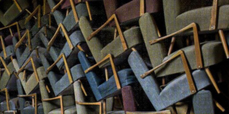 a bunch of chairs piled up