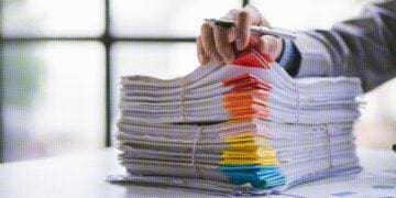 analyst going through stack of papers