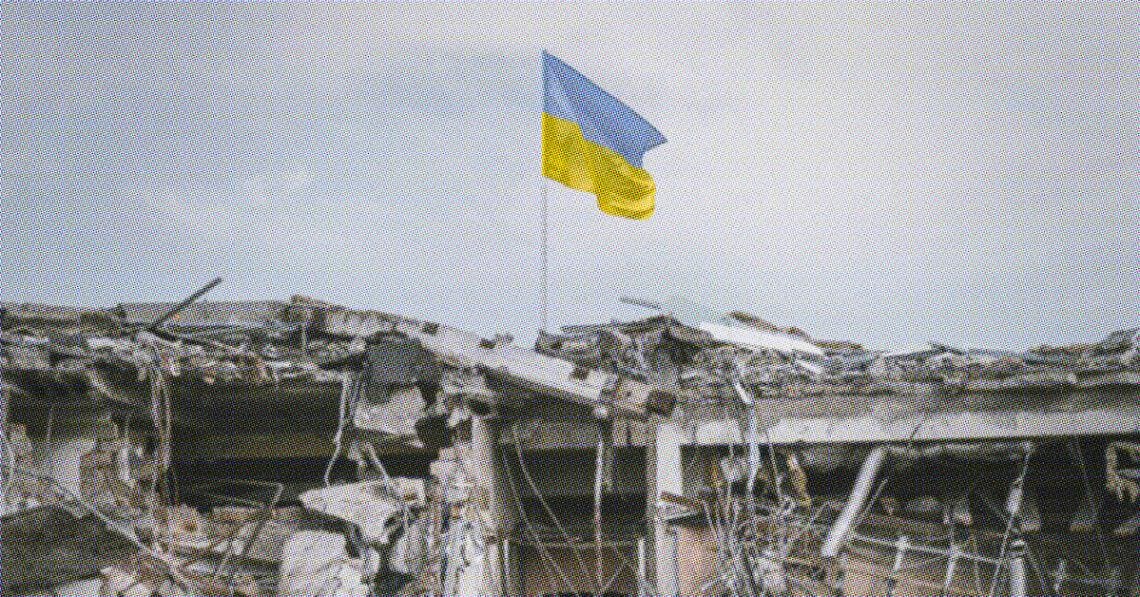 ukraine flag flying above damaged building