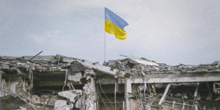 ukraine flag flying above damaged building