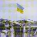ukraine flag flying above damaged building