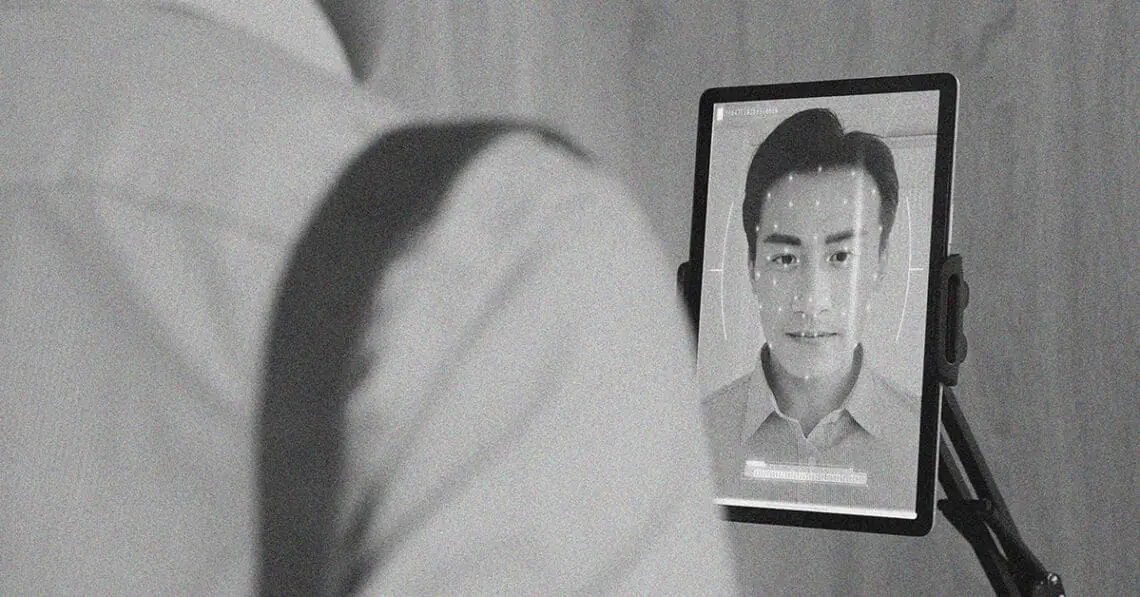 man using facial recognition tablet at work