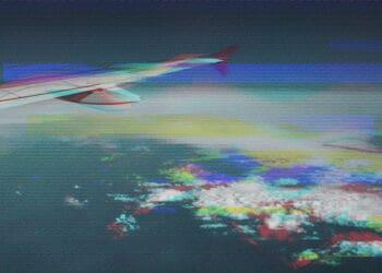 glitchy image of airplane wing mid-flight