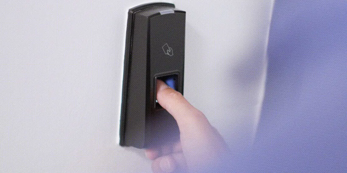 worker using thumbprint machine at door