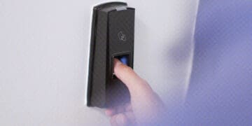 worker using thumbprint machine at door