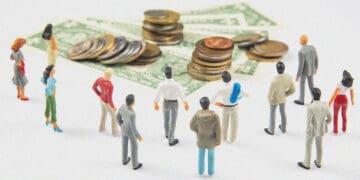 figurines looking at pile of money