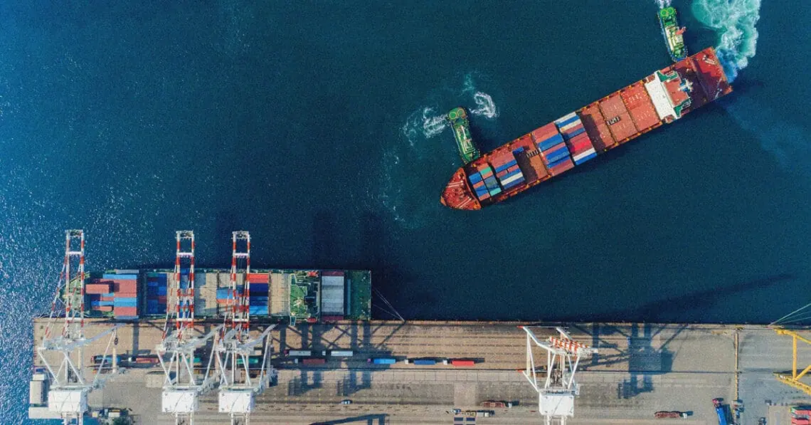 boat loading shipping containers at sea