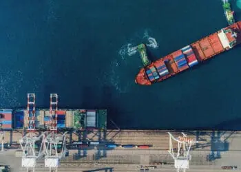 boat loading shipping containers at sea
