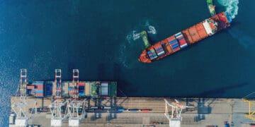 boat loading shipping containers at sea