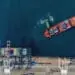 boat loading shipping containers at sea