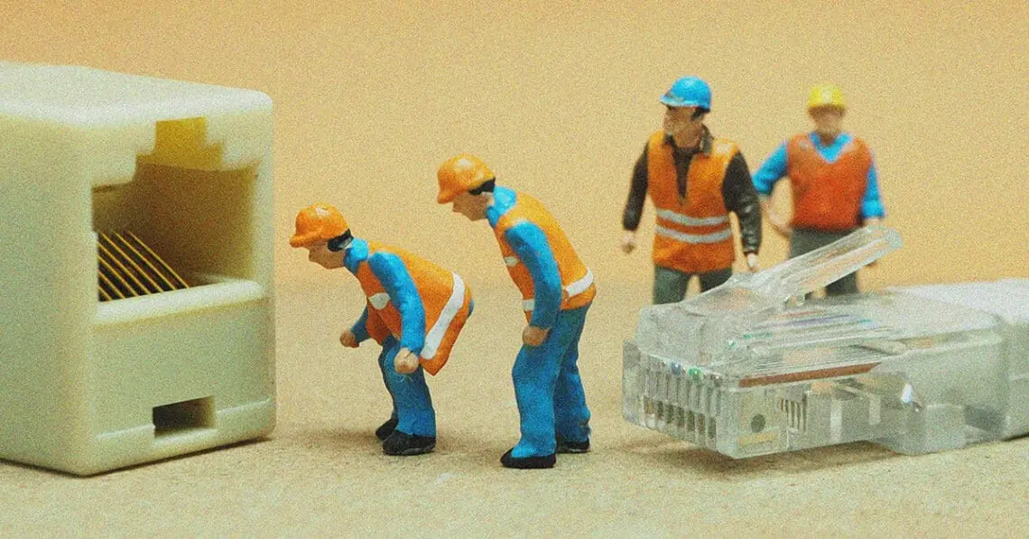 small figurines connecting ethernet cable