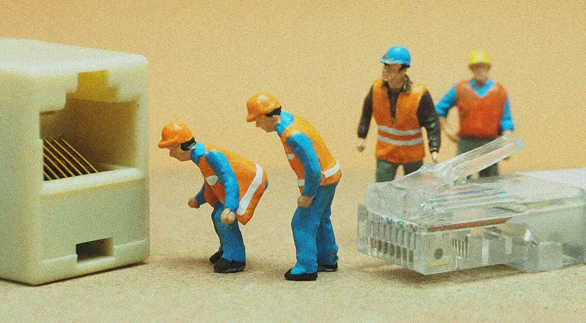 small figurines connecting ethernet cable