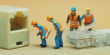 small figurines connecting ethernet cable