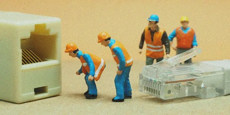 small figurines connecting ethernet cable