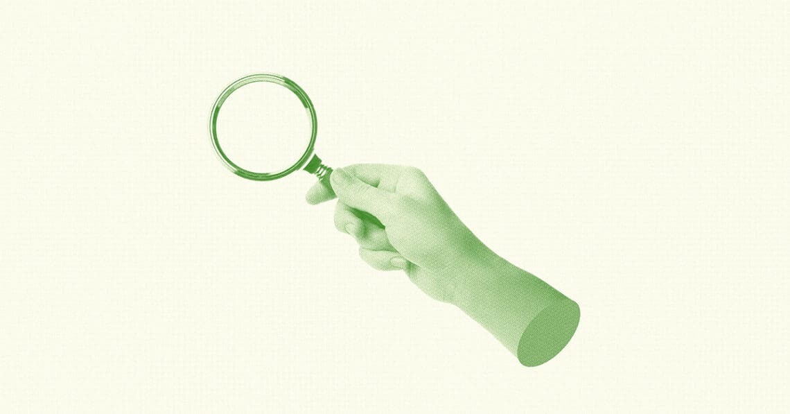 workplace investigation hand holding magnifying glass