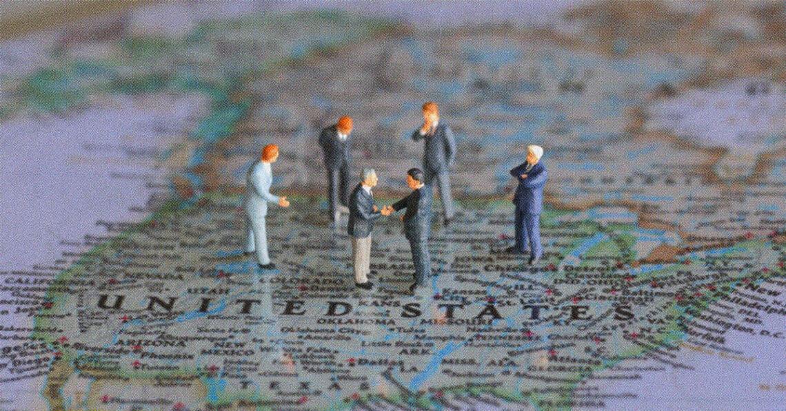 political figurines meeting on top of US map