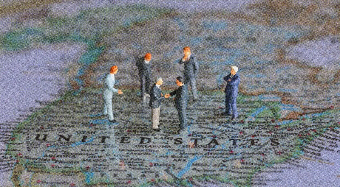 political figurines meeting on top of US map
