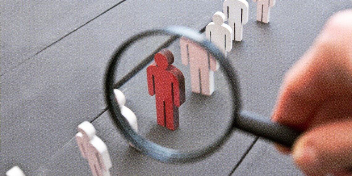 wooden figurines magnifying glass isolating one