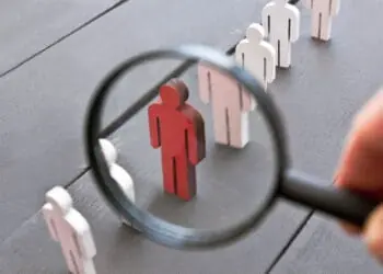 wooden figurines magnifying glass isolating one