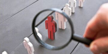 wooden figurines magnifying glass isolating one