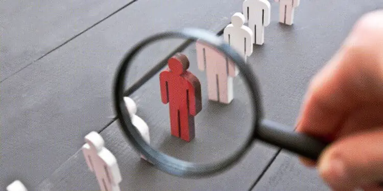 wooden figurines magnifying glass isolating one