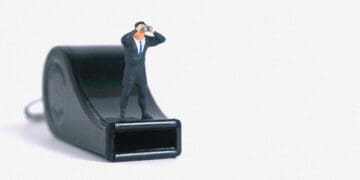businessman figurine on whistle whistleblowing concept