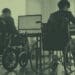colleagues in wheelchairs at desk