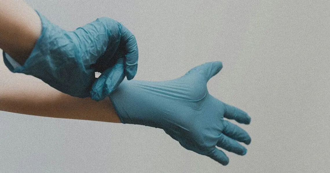 person putting on surgical latex gloves
