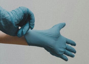 person putting on surgical latex gloves