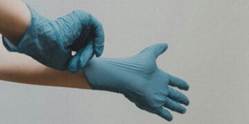 person putting on surgical latex gloves