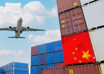 airplane flying over cargo containers