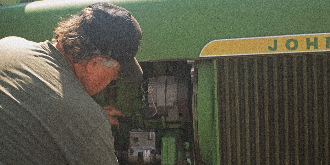 mechanic working on john deere tractor