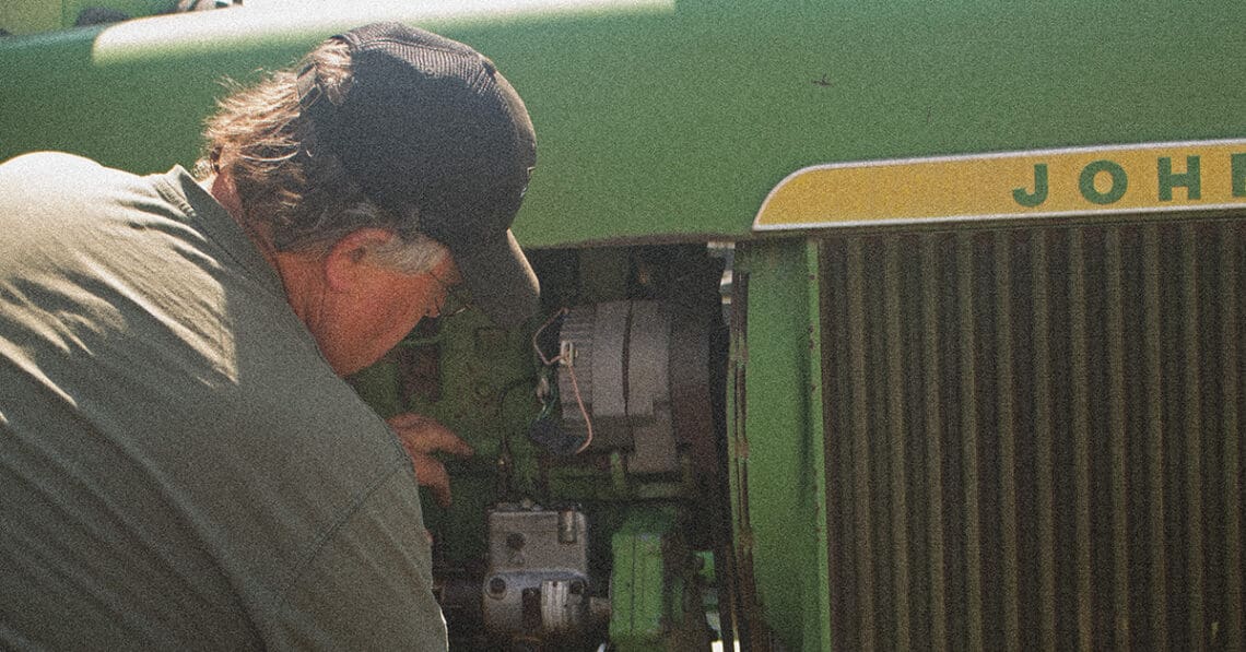 mechanic working on john deere tractor