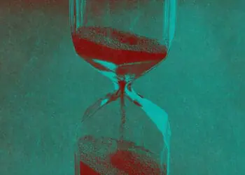 An hourglass with sand flowing into its bottom.