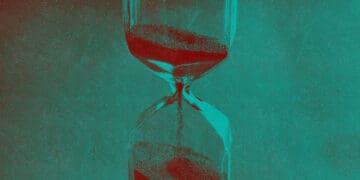 An hourglass with sand flowing into its bottom.
