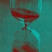 An hourglass with sand flowing into its bottom.