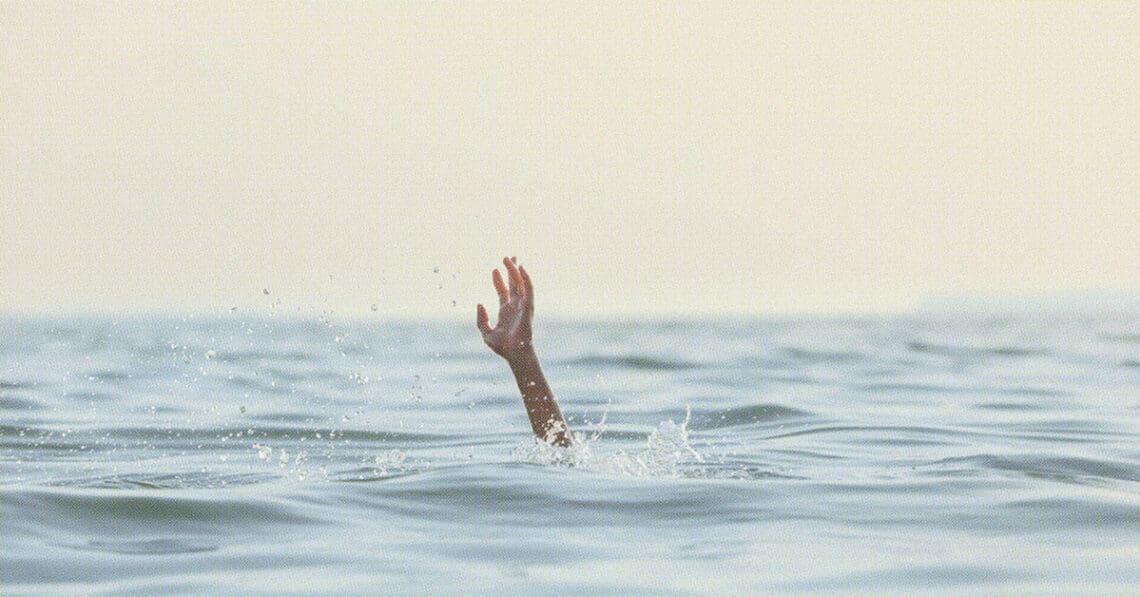 person reaching for help in sea