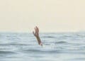person reaching for help in sea