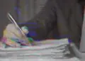 hand on pile of papers
