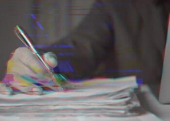 hand on pile of papers