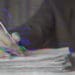 hand on pile of papers